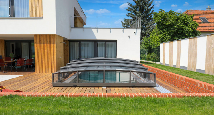 Abri bas de piscine Alukov intégré à une terrasse moderne, offrant sécurité, confort et design élégant pour la vie outdoor