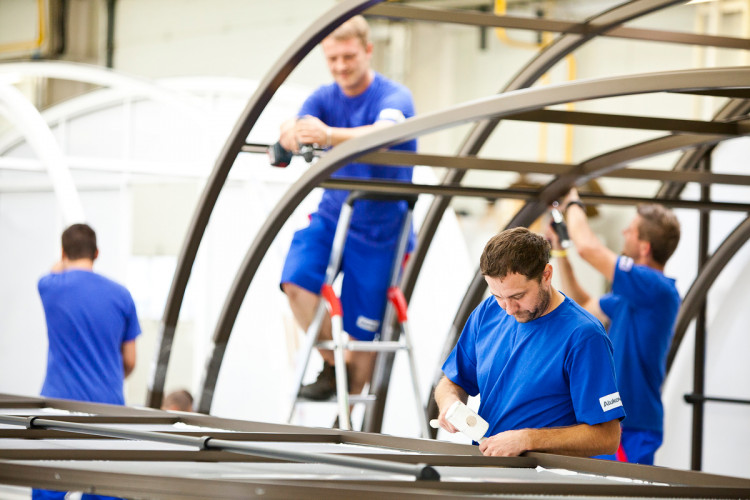 Ouvriers Alukov assemblant des abris en aluminium dans l'atelier de production