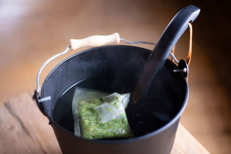 Nystad Sauna infusing herbs in a sauna bucket