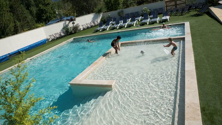 Nouvelle piscine extérieure de 150 m² carrée champignon arroseur buses balneo au camping Les Rives du Lac