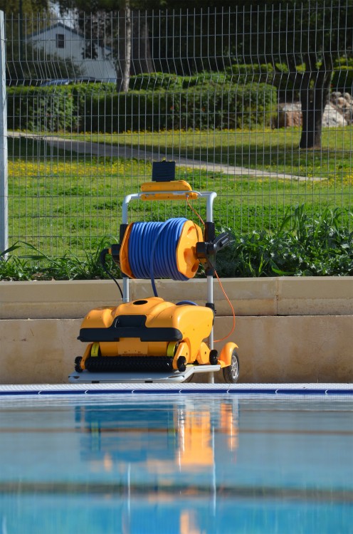robot nettoyeur de psicine collective Dolphin Wave 200 de Maytronics au bord de la piscine sur son chariot
